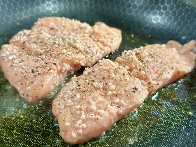 salmon frying in a Hexclad pan