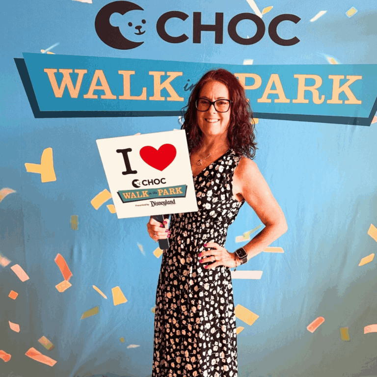 me in a black and white dress standing in front of a CHOC Walk in the park sign; help me fundraise in Disney style at the 2025 CHOC Walk at Disneyland