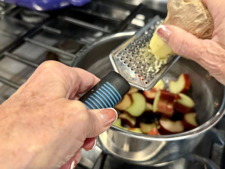 grating ginger into a pan with chopped rhubarb
