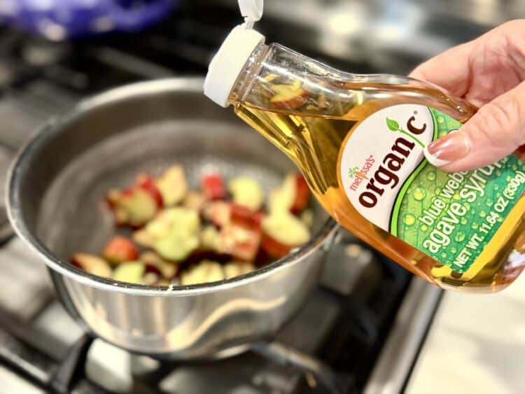 Melissa's Produce agave syrup being poured into a pan of rhubarb