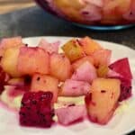 the citrus watermelon and Asian pear salad on the plate on top of avocado crema