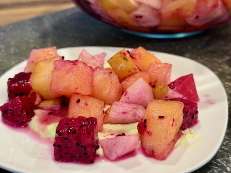 the citrus watermelon and Asian pear salad on the plate on top of avocado crema