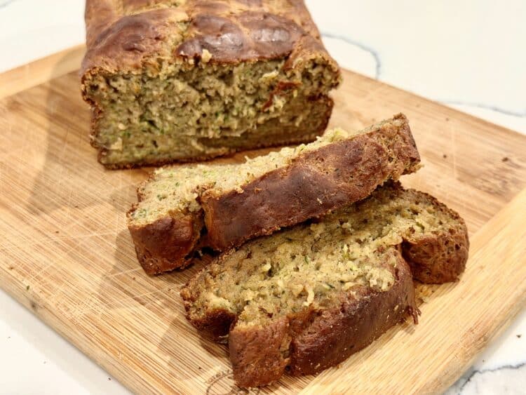 high-protein zucchini bread with surprise additions, sitting on a cutting board on a counter
